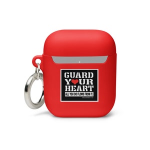 May include: Red silicone case for AirPods with a black and white sticker that says "GUARD YOUR HEART, ALL YOU DO FLOWS FROM IT, PROVERBS 4:23". The case has a silver ring attached to it.