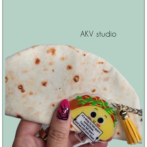 May include: A novelty taco-themed keychain with a yellow tassel. The keychain features a smiling taco graphic with the text "It's okay to fall apart sometimes. Tacos fall apart and we still love them."