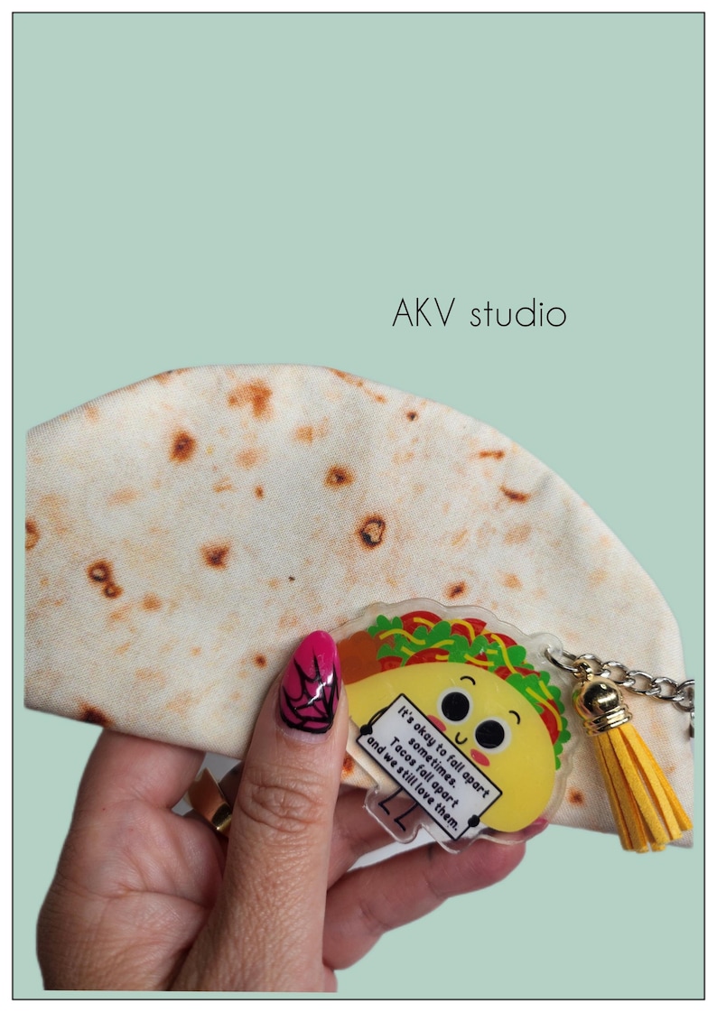 May include: A novelty taco-themed keychain with a yellow tassel. The keychain features a smiling taco graphic with the text "It's okay to fall apart sometimes. Tacos fall apart and we still love them."