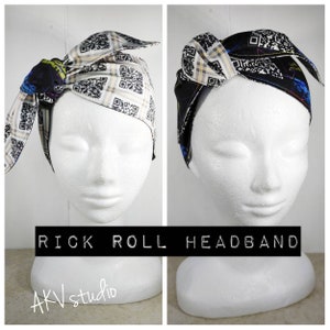 May include: A white headband with a black and white QR code pattern. The headband is tied in a knot on top of the head. The text "RICK ROLL HEADBAND" is printed below the headband.