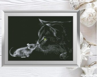 May include: A black cat with green eyes looks at a small grey mouse. The cat and mouse are nose to nose, and the background is black.