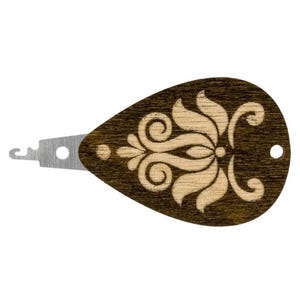 May include: A wooden threader with a brown wood finish and a white floral design. The threader has a metal hook on one end.