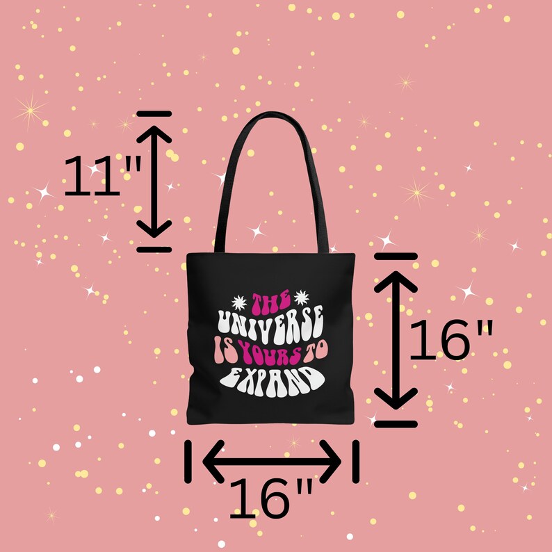 May include: Black tote bag with white and pink text that reads "*THE* UNIVERSE IS YOURS TO EXPAND". The bag measures 16 inches wide by 16 inches tall and 11 inches deep.