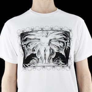 May include: White t-shirt with a black and white graphic print of a winged figure with a skull and smiley face border.