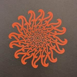May include: A red mandala design with intricate details and a circular pattern in the center.
