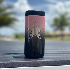 May include: A black and pink stainless steel tumbler with a silver star design. The tumbler has a black lid and a black base.