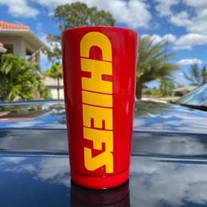 May include: Red stainless steel tumbler with a yellow "CHEERS" graphic.
