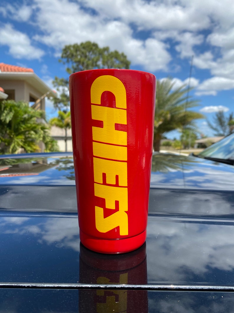 May include: Red stainless steel tumbler with a yellow "CHEERS" graphic.