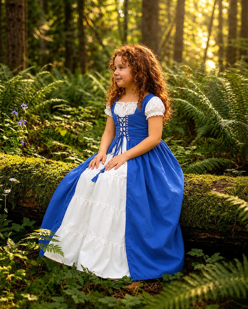 May include: A blue and white dress with a corset-style bodice and a tiered skirt. The dress has short, puffed sleeves and is trimmed with white lace. The dress is worn by a person with red curly hair, sitting on a moss-covered log in a forest setting.