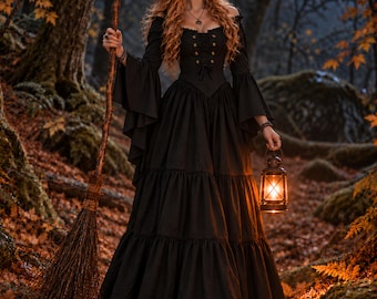 May include: A long black dress with a corset-style bodice, long flared sleeves, and a tiered skirt. The outfit includes a pointed witch hat, a wooden broomstick, and a handheld metal lantern with a warm glowing light in a dark forest setting.