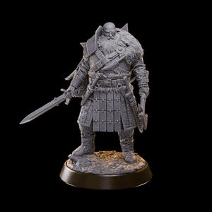 May include: A gray unpainted miniature figurine of a bearded warrior standing on a rocky base. The figure wears layered armor with fur accents, a belted tunic, and tall boots. A sword is held in the right hand, and an axe is held in the left hand.