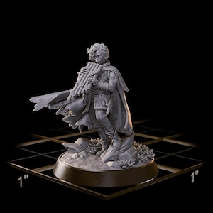 May include: A gray figurine of a person playing a pan flute, wearing a cloak and standing on a rocky base. The figurine is approximately 1 inch in height and width, set against a black background with a grid.