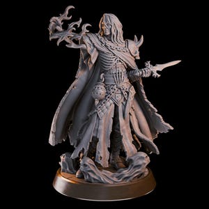 Könnte beinhalten: Eine detaillierte, grau bemalte Miniaturfigur einer skelettartigen Gestalt, die einen zerfetzten Umhang trägt und einen Dolch und eine Phiole hält. Die Figur steht auf einem runden Sockel mit goldfarbenem Rand.
