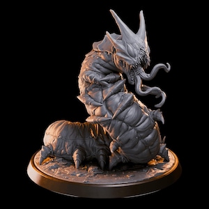 May include: A detailed gray sculpture of a monstrous creature with a segmented body, sharp spikes, and a menacing head with horns and tentacles. The sculpture is set on a round base with a textured surface, against a black background.