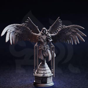 May include: A detailed statue of an angel with large, feathered wings, holding chains. The angel is standing on a small, detailed structure with a cross on top. The statue is a neutral gray color.