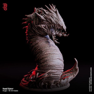 May include: A brown, worm-like creature figurine with a segmented body, sharp teeth, and a jagged head crest. The base is labeled as a 75 mm base. Text on the image includes 'Sand Eater', 'Huge - 75 mm base', and 'May 2026 - THE ENDLESS WASTELANDS'.