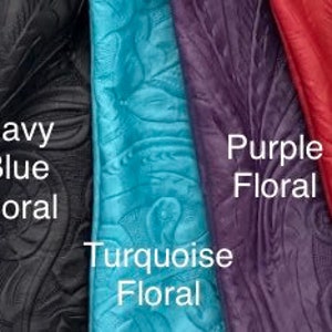 May include: A collection of embossed leather samples in various colors, including black, dark brown, brown, navy blue, turquoise, purple, red, and tan. Each sample features a floral pattern and is labeled with its color and the word "Floral".