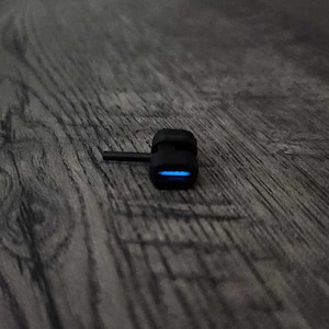 Peut inclure: Un petit adaptateur USB noir avec un voyant lumineux bleu.