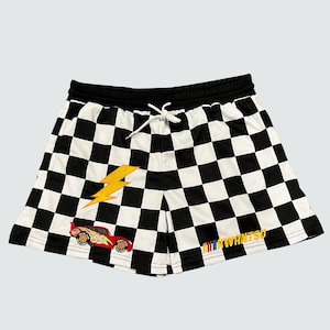 May include: Black and white checkered shorts with a red race car and yellow lightning bolt graphic. The shorts have a black drawstring and the text "KWANTSO" on the bottom.