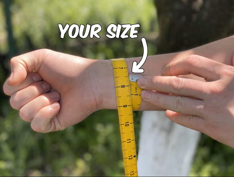 May include: A yellow measuring tape is wrapped around a wrist to measure its circumference. The text "YOUR SIZE" is above the wrist. The tape is marked in inches, with the measurement at approximately 7 inches.