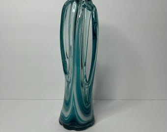 May include: A tall, clear glass vase with a unique, twisted design. The vase has a blue and white swirl pattern.
