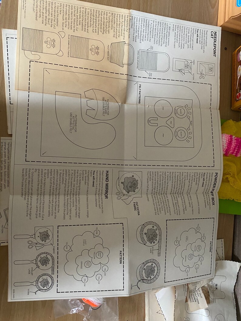 May include: Instructions for making a needlepoint cat, hand mirror, and powder puff box. The instructions include patterns for each project and a list of materials needed.