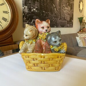 Large ceramic cats in basket