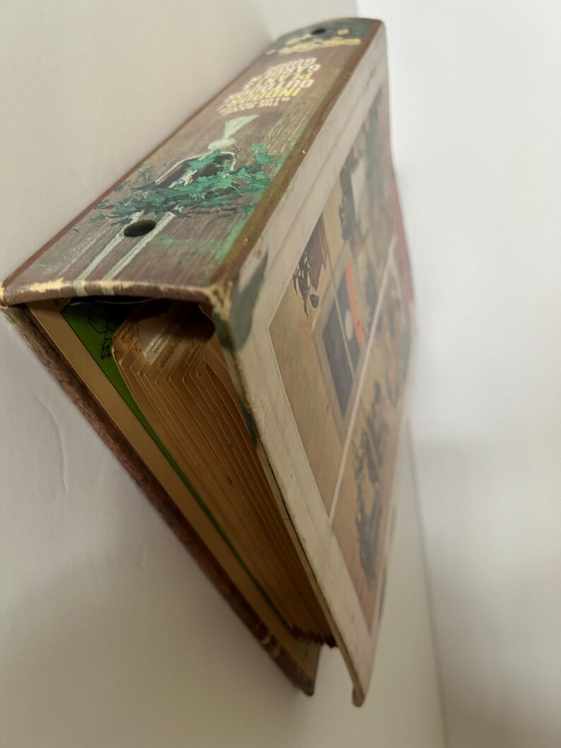 May include: Vintage hardcover book with a worn, rustic appearance. The spine features text and a decorative illustration of a figure in a forest setting. The book's pages are aged, and the cover displays a collage of images.