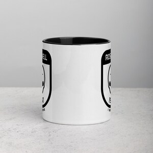 Pu&ograve; includere: Tazza da caff&egrave; in ceramica bianca con bordo e manico neri. La tazza presenta una grafica in bianco e nero di un UFO con il testo "Roswell" e "I Believe" su entrambi i lati.