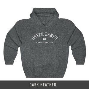 Puede incluir: Sudadera con capucha de color gris oscuro jaspeado con texto blanco que dice "Outer Banks" en arco con "OBX" en un c&iacute;rculo sobre el texto y "North Carolina" debajo del texto.