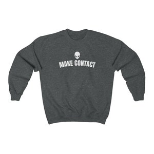 May include: Dark gray sweatshirt with a white alien head graphic and the text "MAKE CONTACT" printed on the front.
