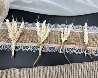 May include: Five bundles of dried wheat stalks tied with twine, arranged on a burlap and lace background. The wheat stalks are a light beige color and are tied with twine.