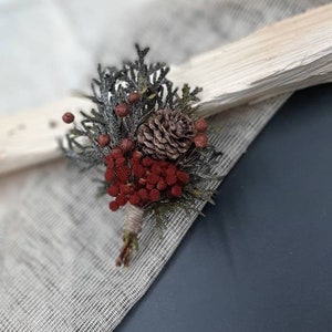 素朴なブートニア 冬のブートニア ウッドランドの結婚式のブートニア 花婿の付添人のボタンホールの花の松ぼっくりのブートニア クリスマス結婚式