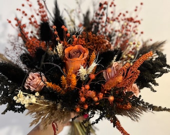 May include: A dried flower bouquet with orange, pink, and black flowers, and brown and beige grasses. The bouquet is tied with a red ribbon.