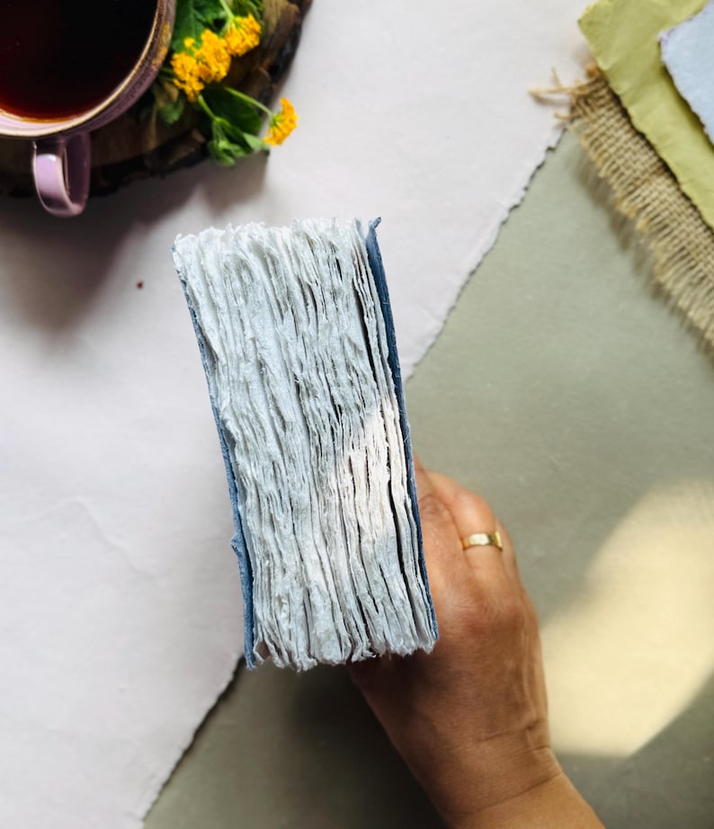 May include: A set of three ceramic mugs with a speckled, matte finish. Each mug features a different color: light blue, cream, and gray. The mugs have a simple, modern design and a comfortable handle. Perfect for coffee or tea.