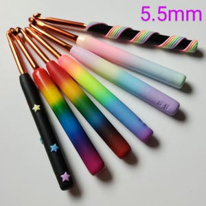May include: A set of seven 5.5 mm crochet hooks with rainbow ombre handles and black handles with star accents.