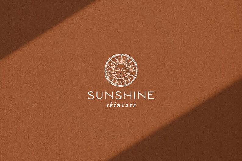 Puede incluir: Un sol blanco con una cara dentro de un c&iacute;rculo con un borde decorativo. El texto "SUNSHINE skincare" est&aacute; debajo del sol.