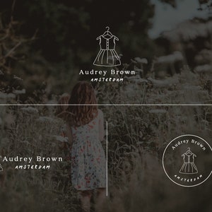 May include: A logo design for a clothing store called Audrey Brown Amsterdam. The logo features a simple line drawing of a dress on a hanger. The logo is displayed on a white background with a green and brown blurred background.