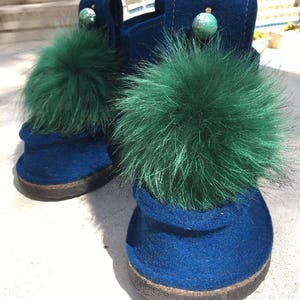 May include: Pair of blue felt boots with green fur pom-poms and decorative accents.
