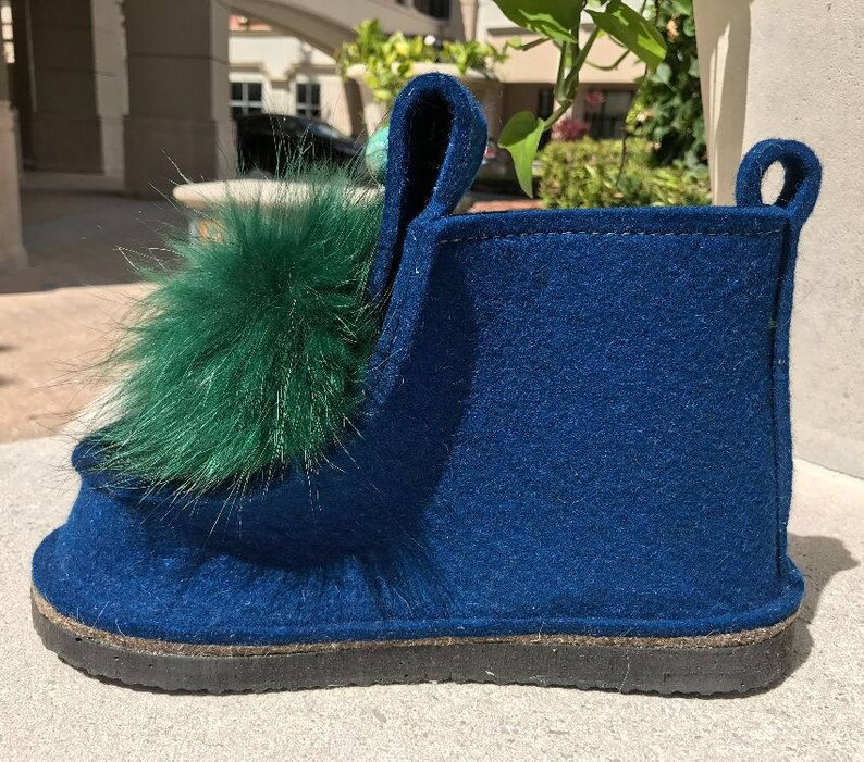 May include: Blue felt slipper with a green fur pom-pom on the top.