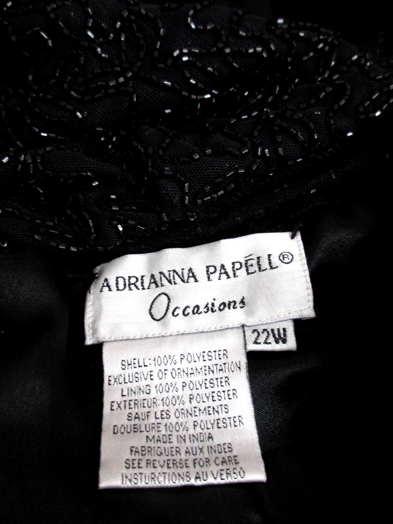 Puede incluir: Vestido de noche negro con adornos de cuentas. La etiqueta dice "ADRIANNA PAPELL Occasions" y la talla es 22W. Composici&oacute;n: 100% poli&eacute;ster para la capa exterior, forro y exterior.