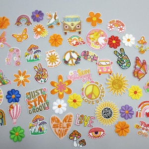 May include: A collection of assorted colorful stickers featuring various designs including flowers, rainbows, butterflies, mushrooms, peace signs, vans, hearts, and text such as Just Stay Groovy, Love, Peace, and More Self Love on a plain background.