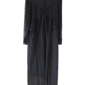 Puede incluir: Un vestido largo negro con corpi&ntilde;o de cuentas y mangas largas. El vestido tiene una falda fluida y cierre de cremallera en la espalda. La parte superior del vestido est&aacute; cubierta de peque&ntilde;as cuentas brillantes.