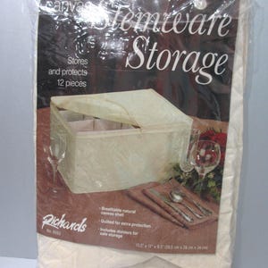 May include: Stemware storage container made of natural canvas. The container is quilted for extra protection and includes dividers for safe storage. The container measures 15.5" x 11" x 9.5".