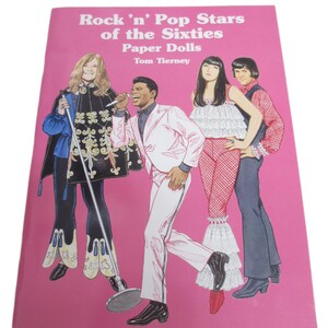 May include: A pink book cover titled Rock 'n' Pop Stars of the Sixties Paper Dolls by Tom Tierney. The cover features illustrations of four figures in 1960s attire, including a person with a microphone, a person in a cape, and two others in patterned outfits.