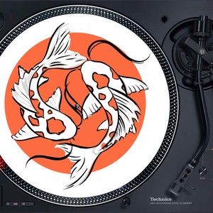 May include: A black turntable with a white slipmat featuring two koi fish swimming in an orange circle. The turntable has a silver tone needle and a black tone arm.