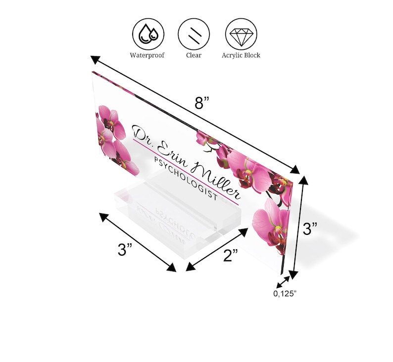 May include: A clear acrylic desk sign with a pink orchid floral design. The sign reads "Dr. Erin Miller, Psychologist". The sign is 20.3 cm wide, 7.6 cm tall, and 0.3 cm thick.