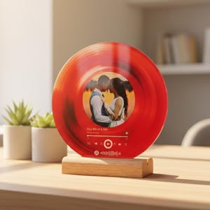 May include: A red, circular decorative piece resembling a vinyl record, featuring a couple's photo in the center. The record is mounted on a wooden base. The text "You Mind & Me" is visible.