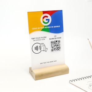 May include: A white sign with a Google logo and the text "Leave us your review on Google". The sign also has a QR code and instructions to tap your phone on the Google icon.