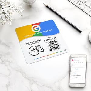 May include: A white sign with a Google logo and the text "Leave us your review on Google". The sign has two options for leaving a review: tap your phone on the Google icon or scan the QR code.